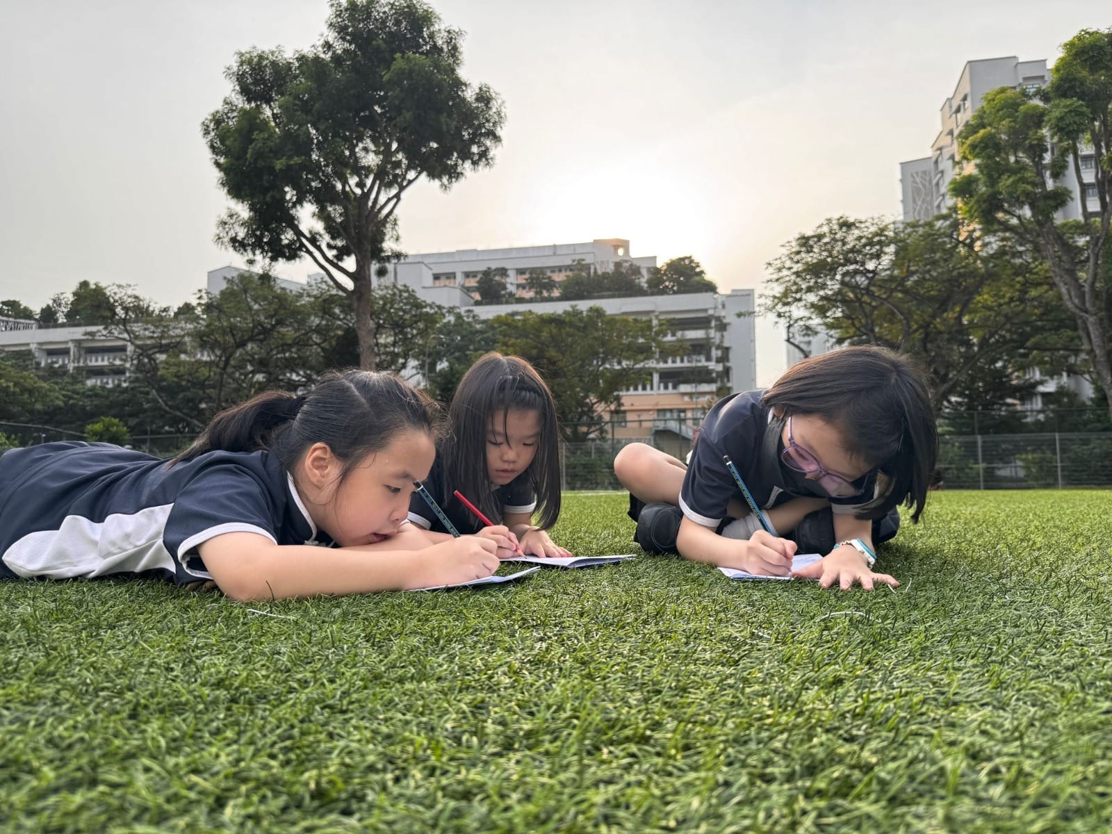 Two students drawing at the field